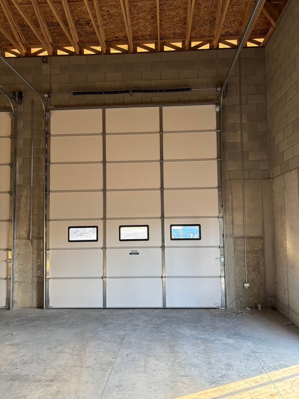 Large industrial garage door in a newly constructed building interior.