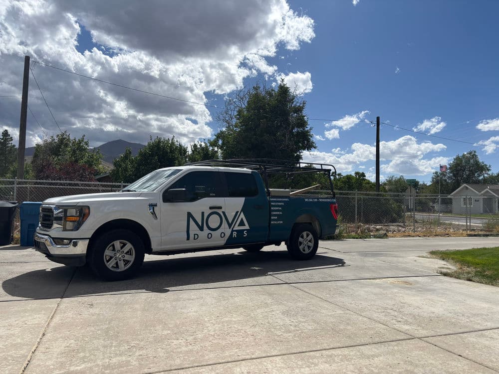 NOVA Doors truck parked in a residential area under a cloudy sky.