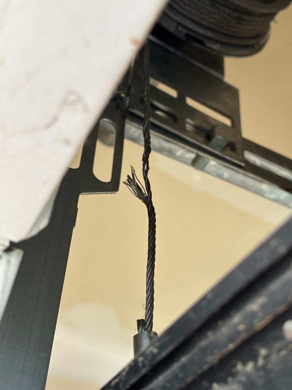 Frayed cable inside machinery, indicating potential maintenance or safety issues.