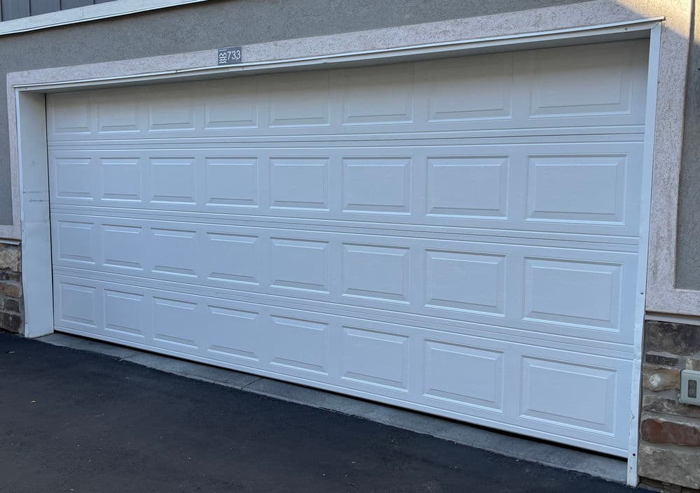 White garage door with raised panels on a residential building exterior.