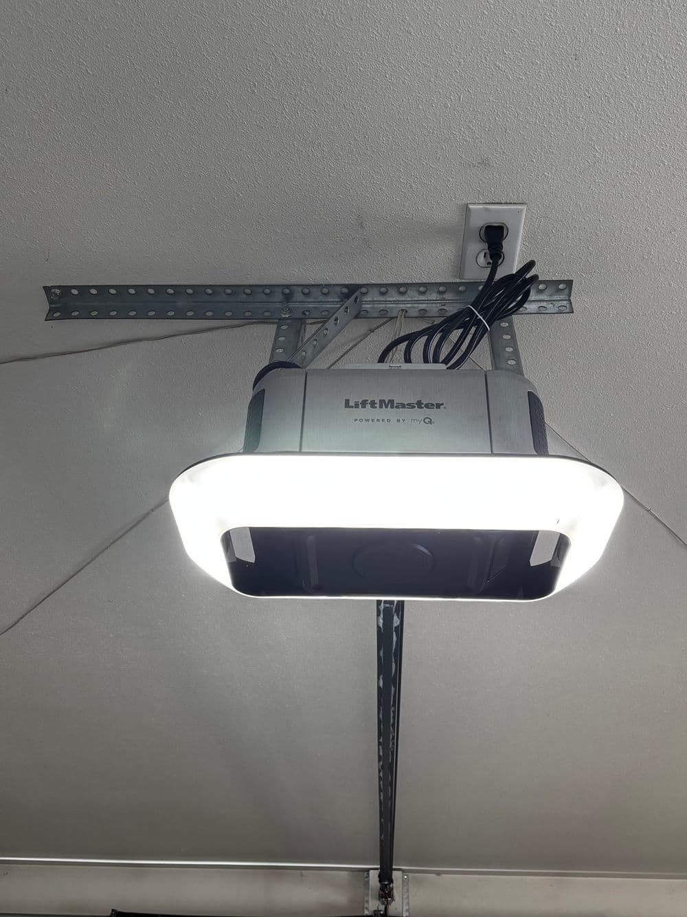 LiftMaster garage door opener mounted on ceiling with bright LED light.