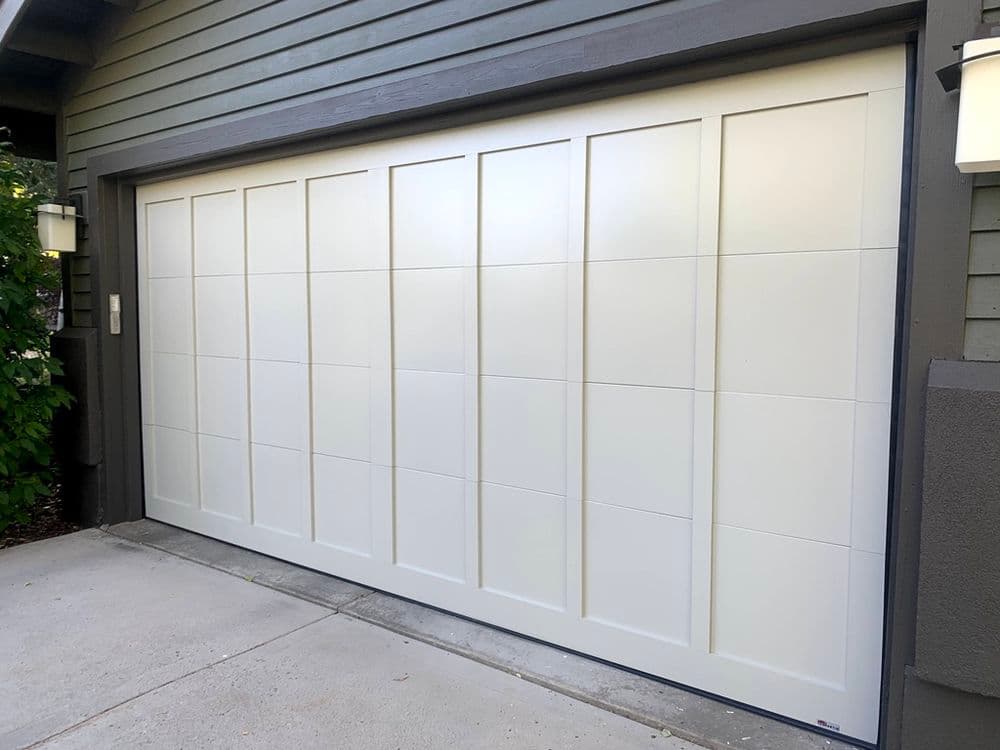 Modern white garage door with horizontal panel design on a gray house exterior.