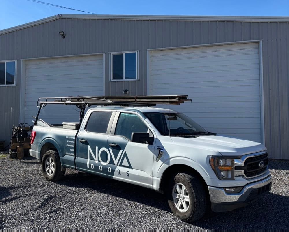 Ford truck with Nova Doors branding parked outside a warehouse.