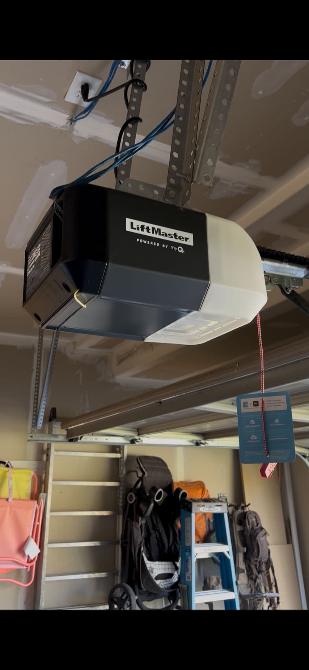 LiftMaster garage door opener mounted on wall, featuring myQ technology for smart control.
