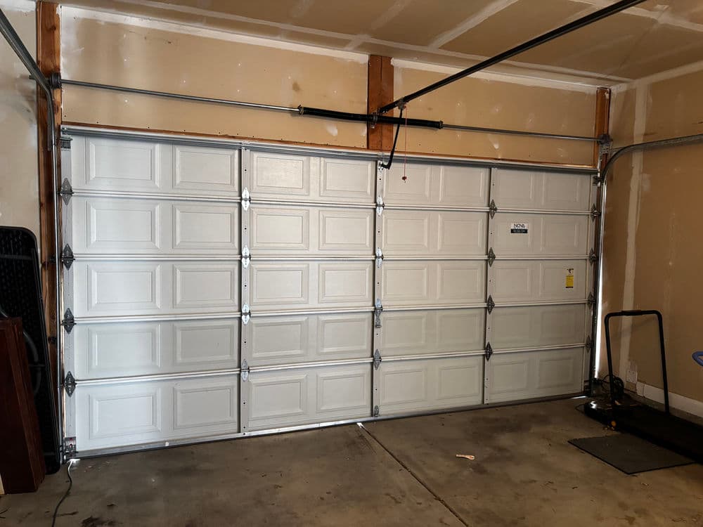 Interior view of a closed white garage door in a residential garage setting.