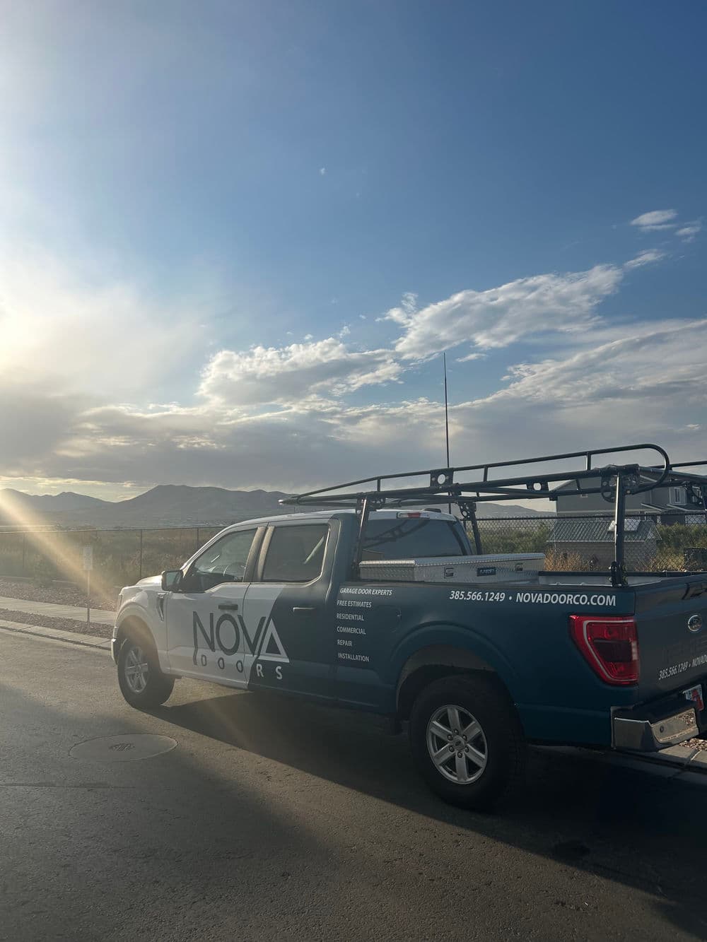 NOVA Doors truck parked near mountains, showcasing vehicle branding and services offered.