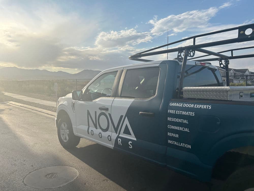 Nova Doors truck with branding, parked outdoors against a scenic backdrop, showcasing service offerings.
