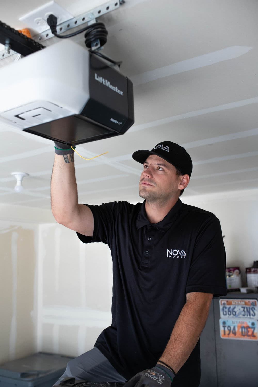 Technician installing LiftMaster garage door opener in residential garage for NOVA.